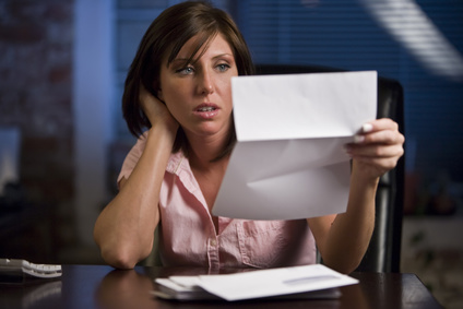 Distressed woman looking at bills. 